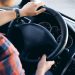 7 money-saving driving tips shown by driver on steering wheel